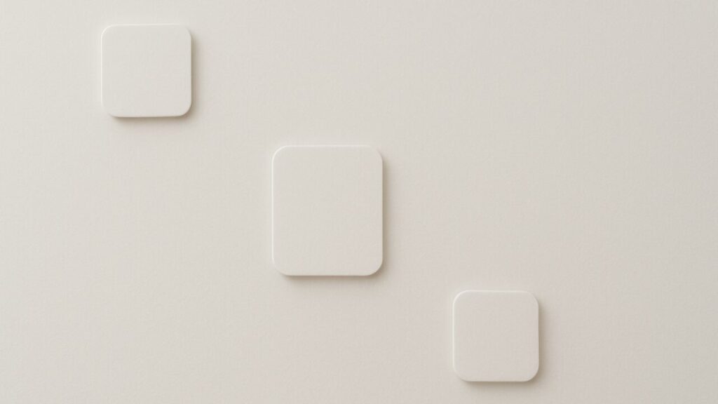 白い無地の面に抽象的なプレートが三つ配置され、手前と奥の層がそっと分かれて読まれるように見える構図。静かな明暗差が、面の上で揺れる層の印象を表現したアイキャッチ。