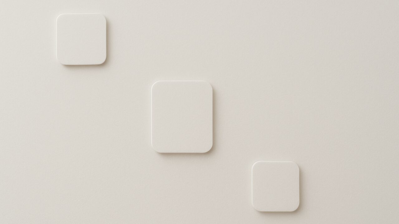 白い無地の面に抽象的なプレートが三つ配置され、手前と奥の層がそっと分かれて読まれるように見える構図。静かな明暗差が、面の上で揺れる層の印象を表現したアイキャッチ。